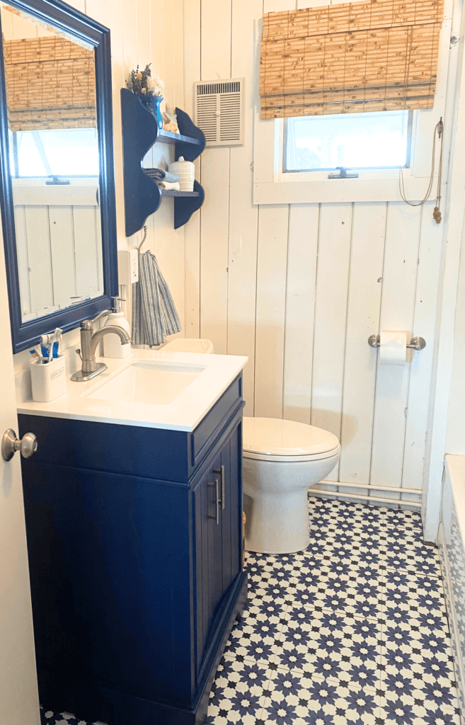 budget cottage bathroom with blue vanity and blue pattern floor