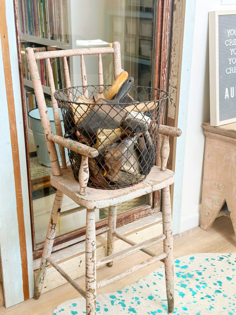 vintage high chair with basket of collected vintage brushes