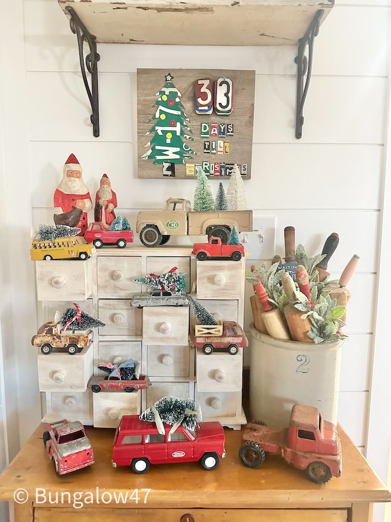 vintage toy trucks displayed with Christmas bottle brush trees