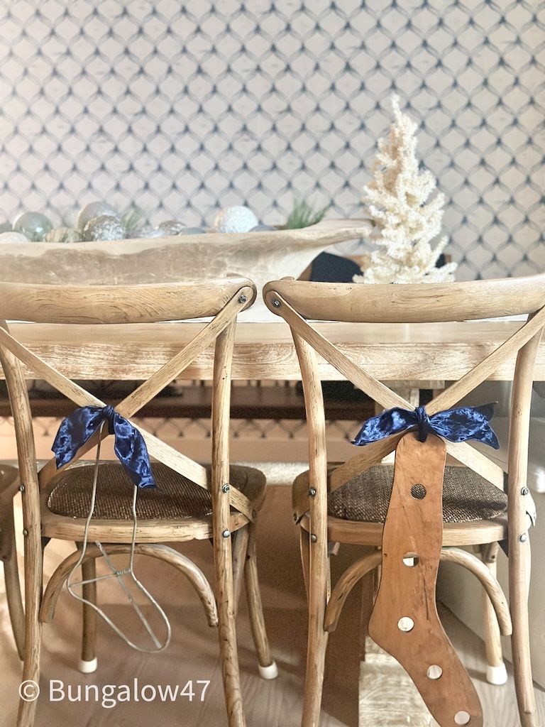 wood and metal vintage sock stretchers hanging on backs of dining room chairs