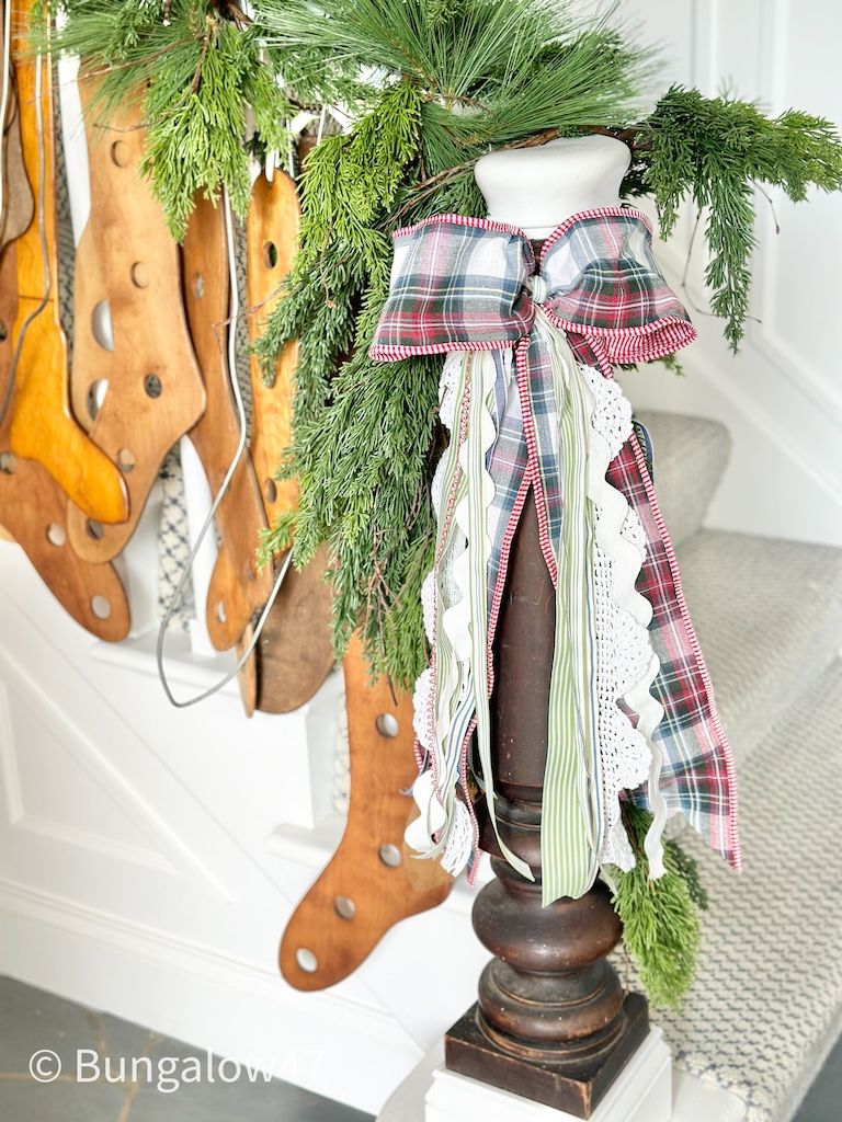 vintage wood sock stretchers on a bannister with Christmas ribbon