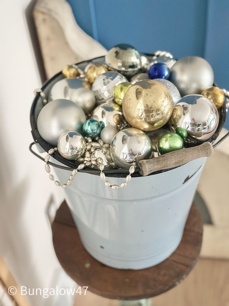 blue vintage enamelware bucket with Christmas ornaments and bead garland