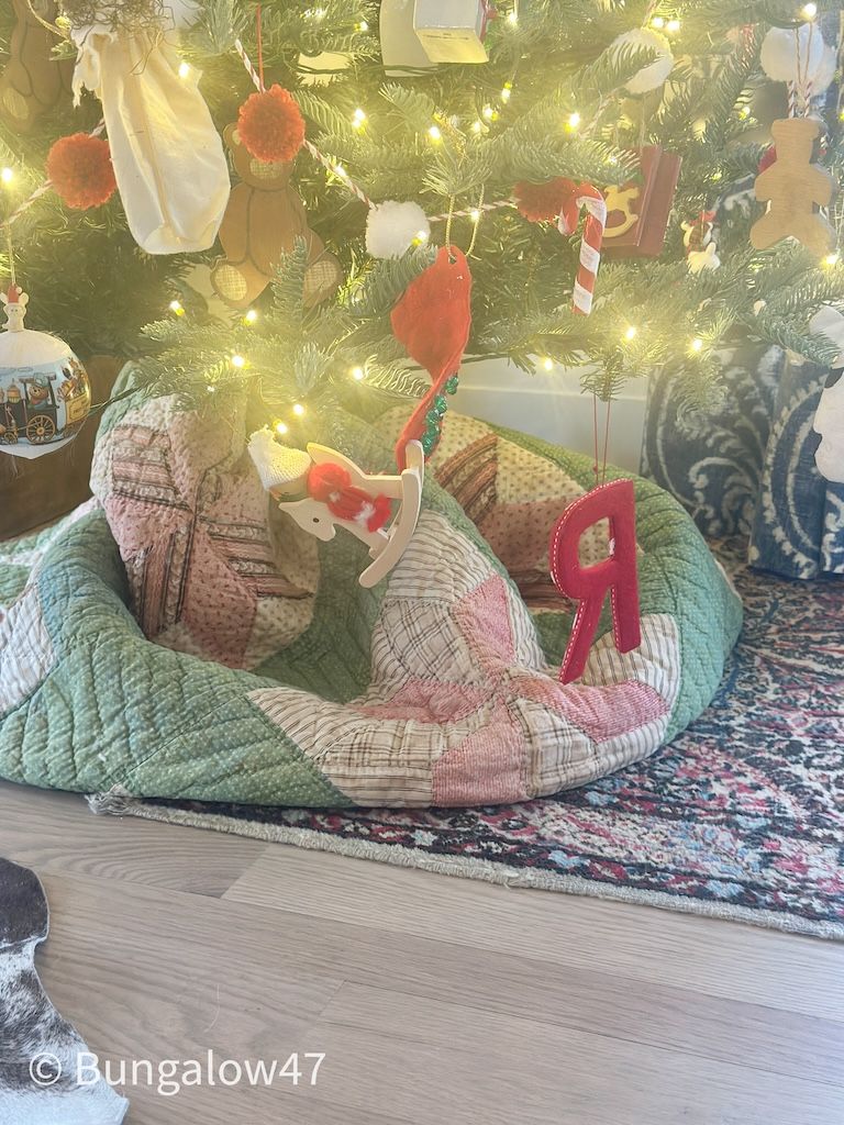 vintage quilt folded up as tree skirt under Christmas tree